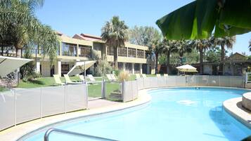 Una piscina al aire libre, sombrillas