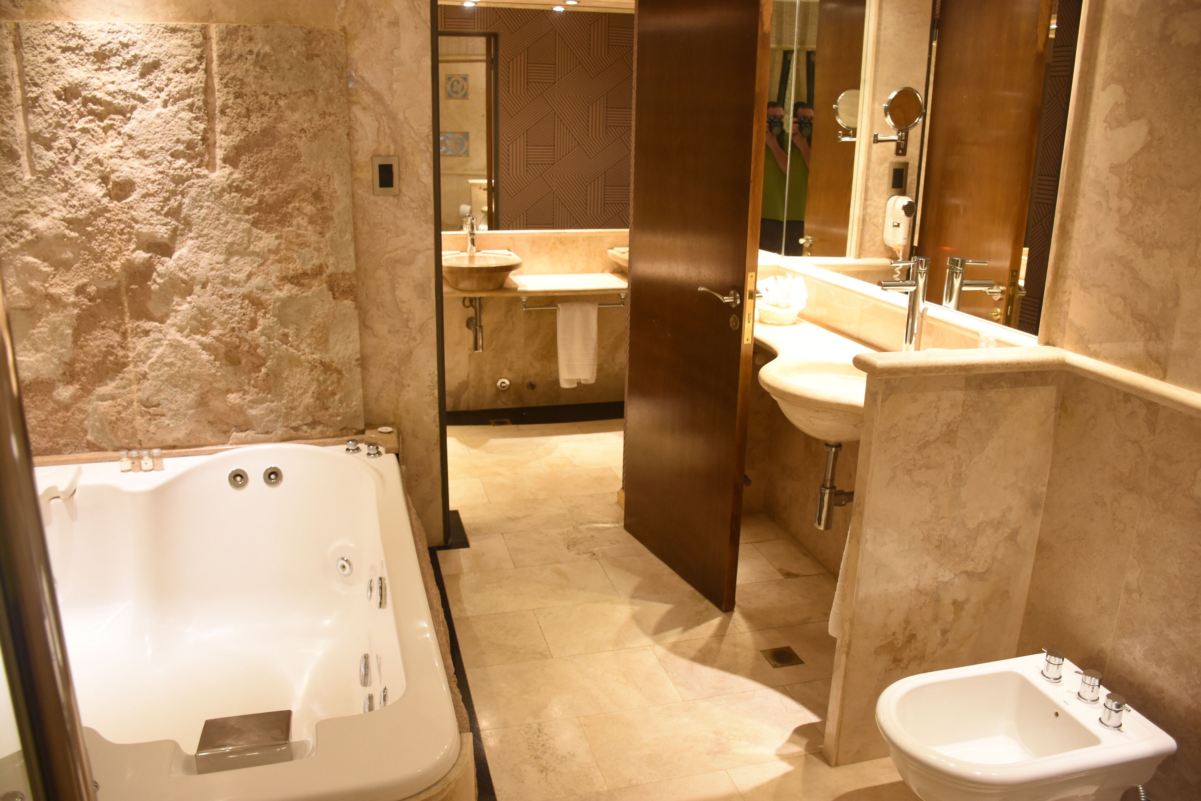 Un baño moderno con una bañera grande, un lavamanos independiente y un bidé.