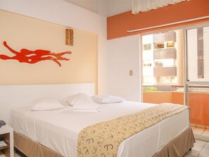 A hotel room with a bed, a window with a view of a building, and a red abstract artwork on the wall. - Lagoa Mar (Maceiä)