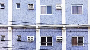 Ein Hotel mit blauer Fliesenfassade, Hausnummer 926, mit schwarzem Eingang und einem Schild, auf dem "HOTEL Safari" steht.