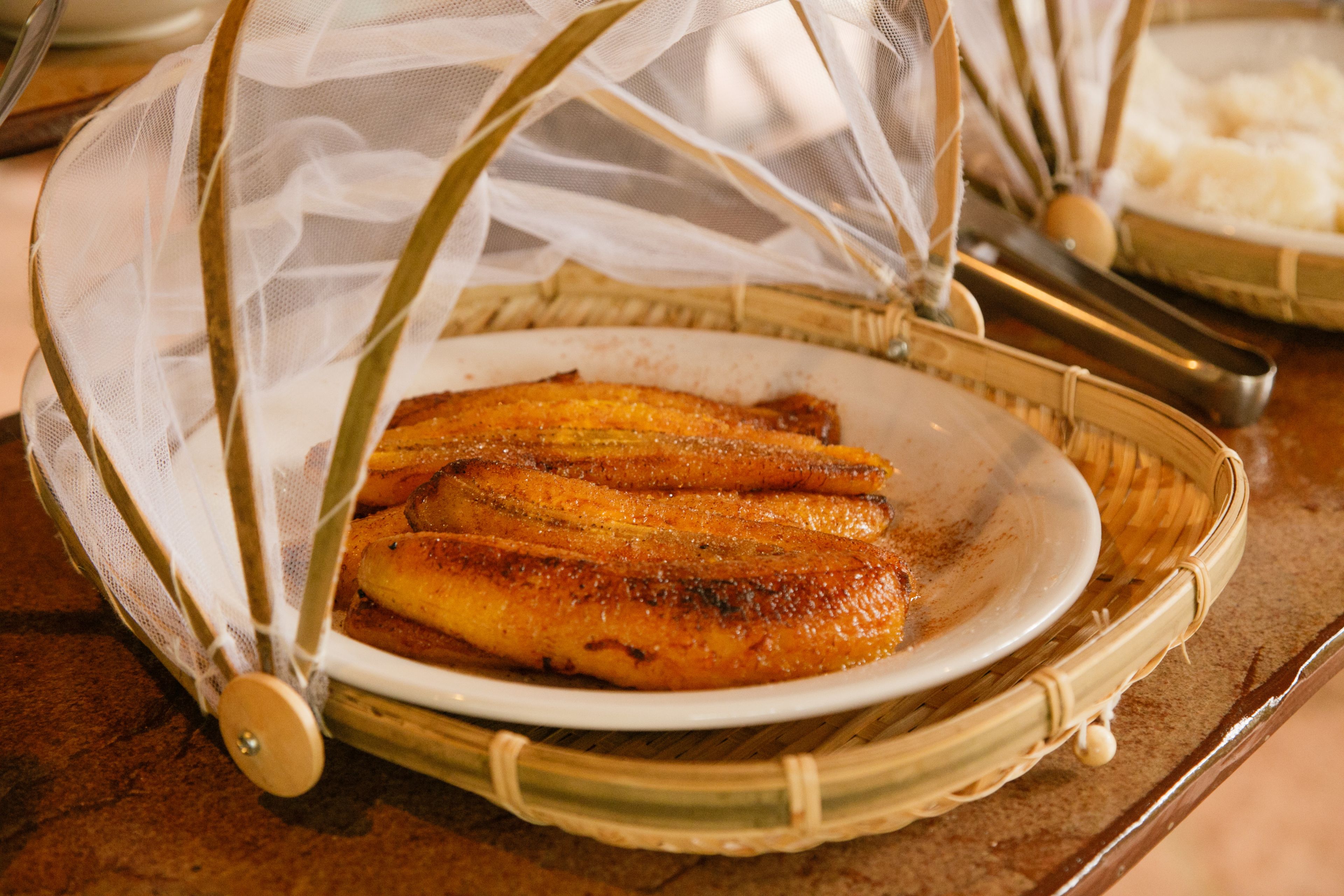 A basket with a white cloth cover containing a plate of food.