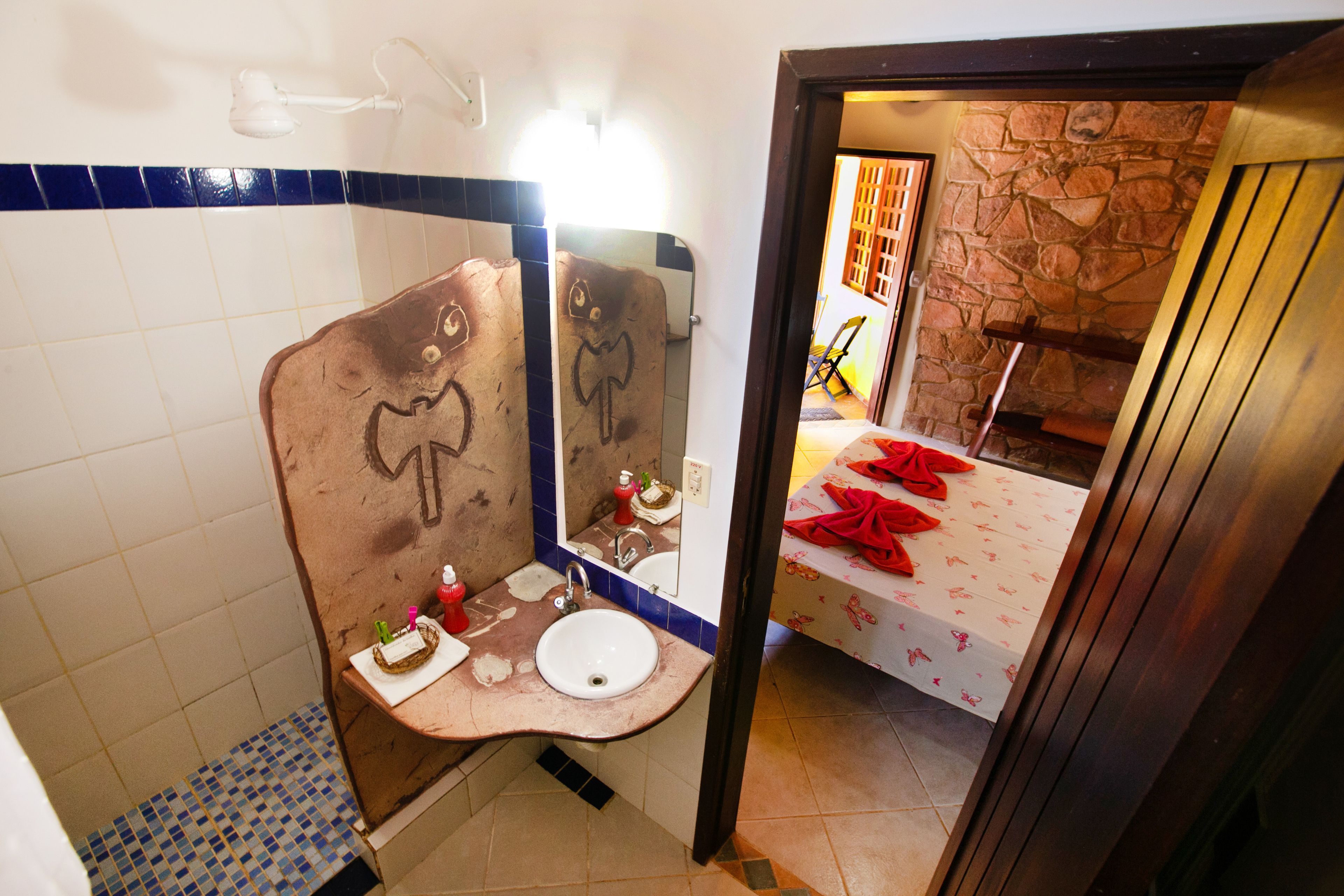 A bathroom with a sink, mirror, and tiled walls.