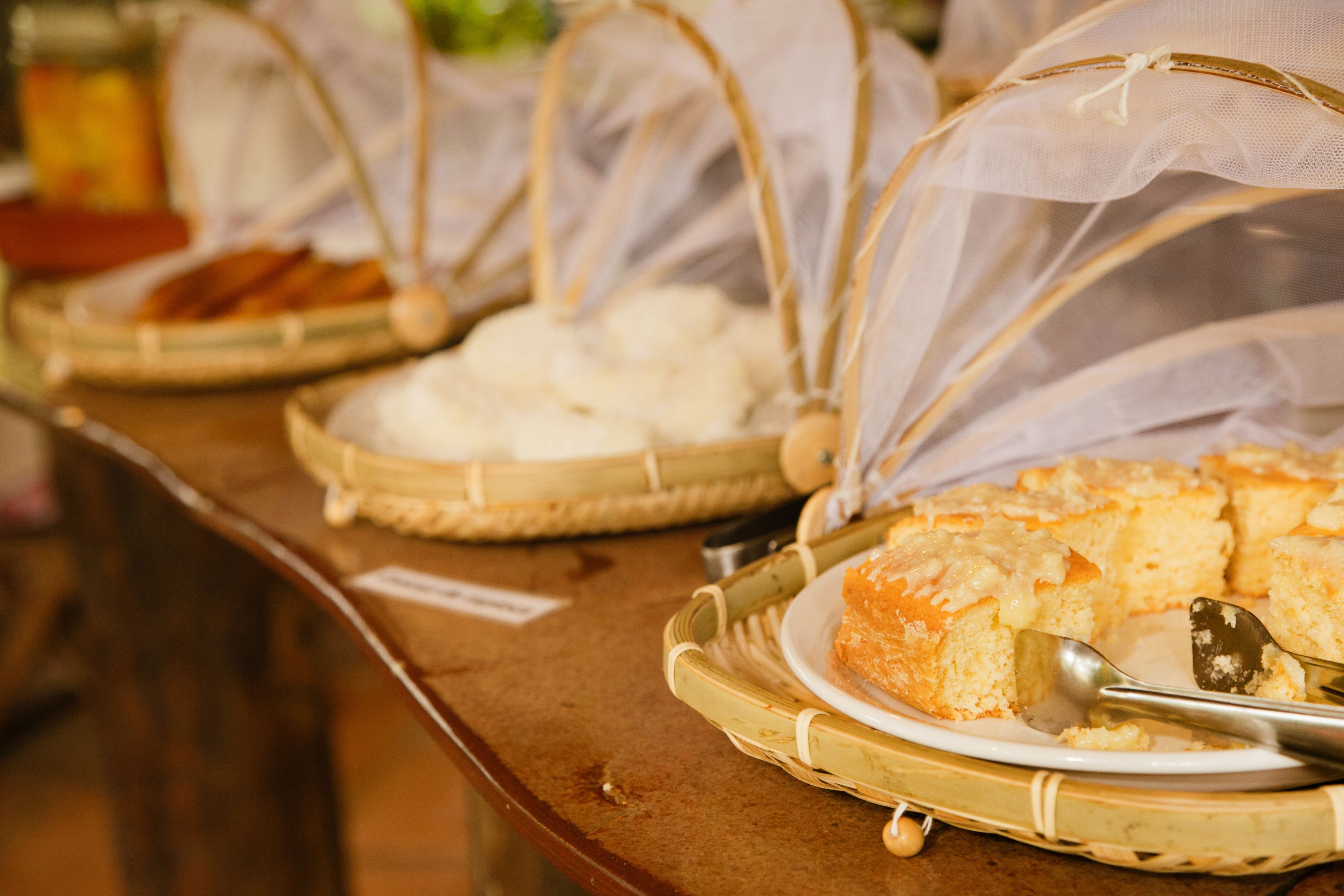A buffet table with various food items covered in mesh.