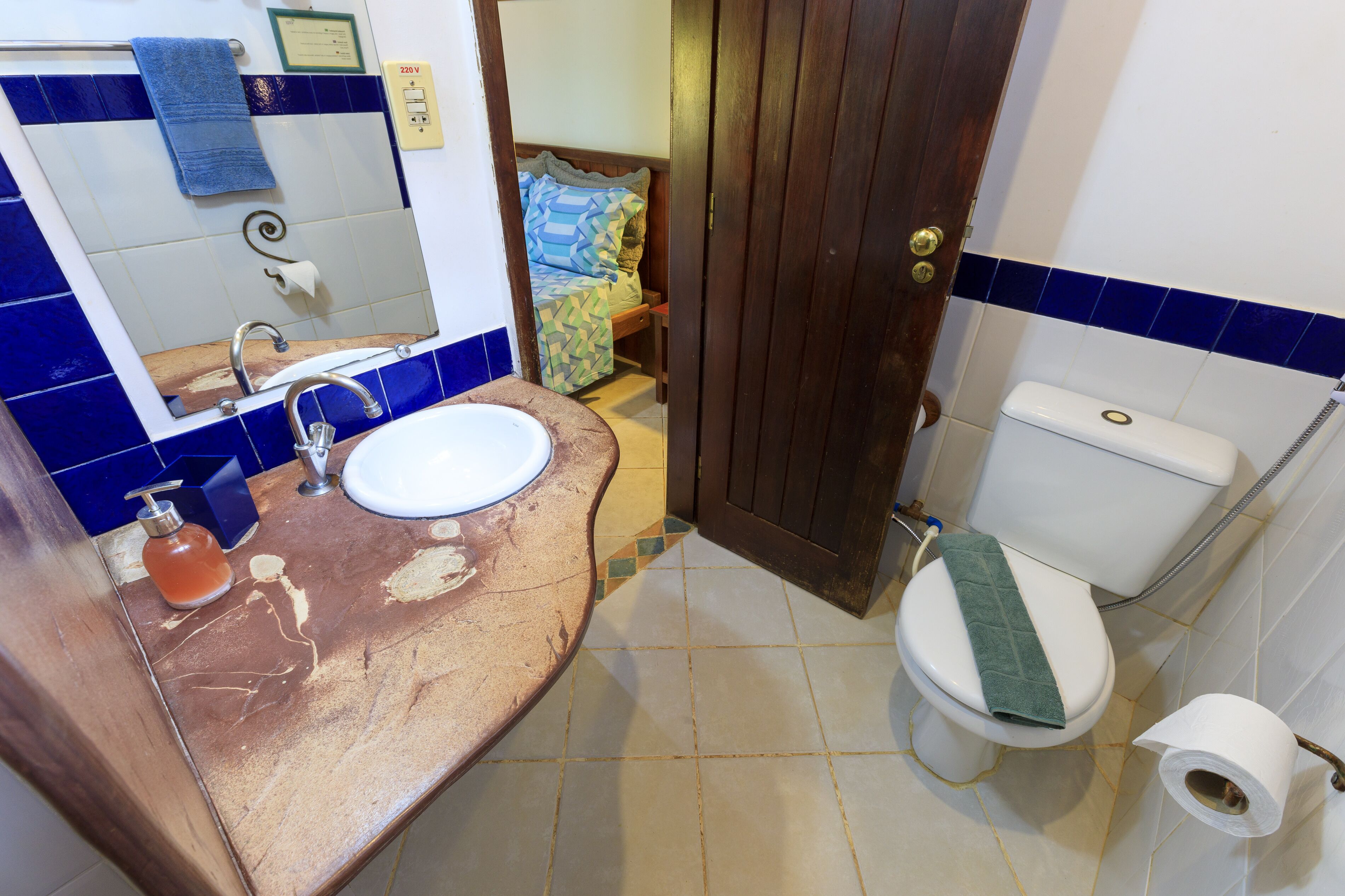 Une salle de bain avec un lavabo, des toilettes et un miroir.