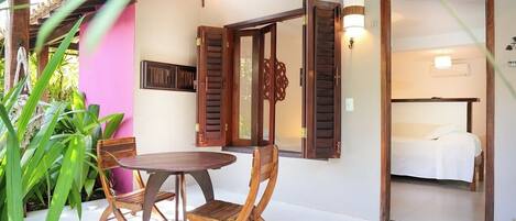A room with a bed, a wooden table, and chairs.