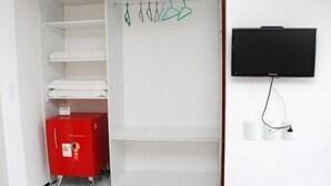A room with a white wardrobe, a red cabinet, and a black TV mounted on the wall. - Pousada Costa Marina (Fortaleza)