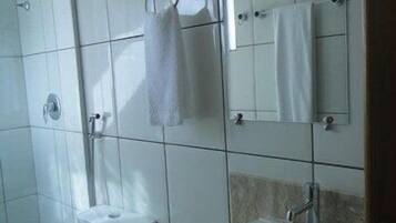 Un baño con inodoro, lavamanos y ducha.