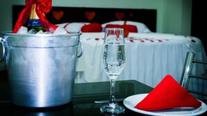 A bed with a heart-shaped pillow and a heart-patterned bedspread. - Syros Hotel (Gama)
