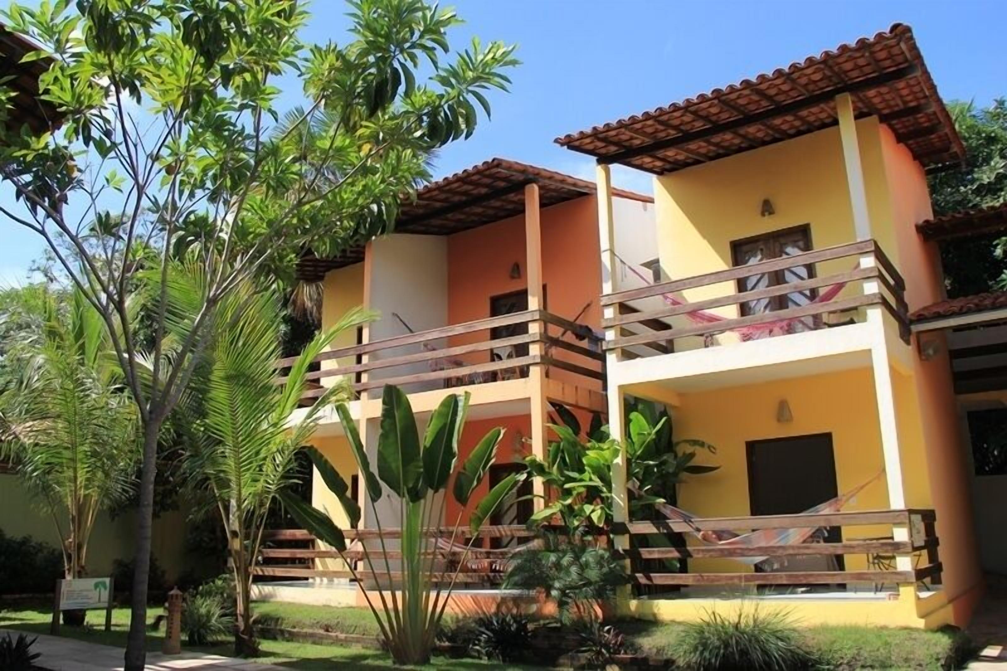 A two-story building with balconies and a garden area.