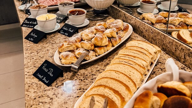 Un bufé con diversos alimentos y etiquetas que identifican los distintos platos.