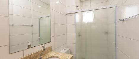 Une salle de bain moderne avec un lavabo en marbre, des toilettes et une douche à parois de verre.