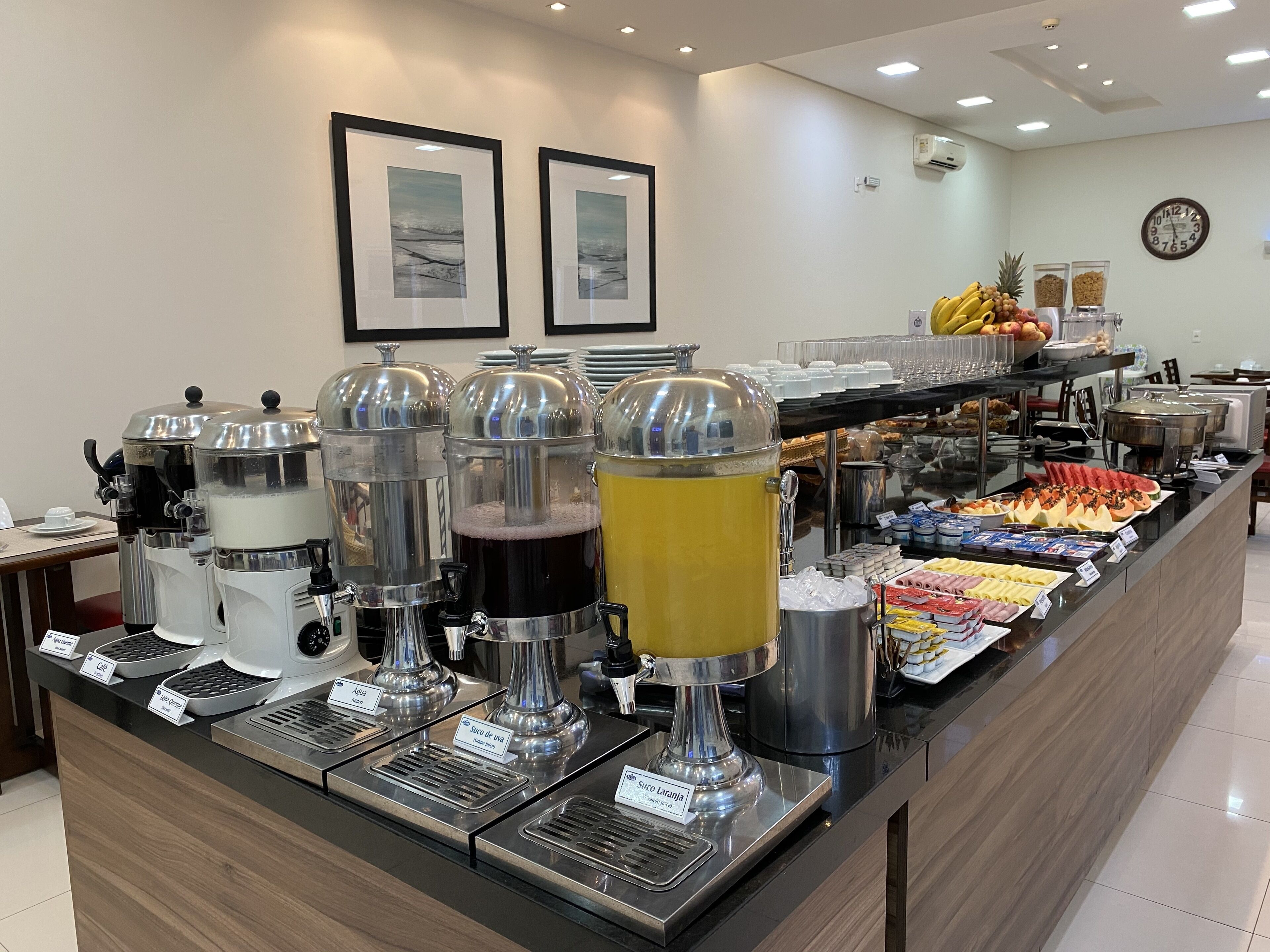 A buffet area with various food and drink dispensers, including coffee and juice options.