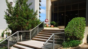 Una escalera con barandillas metálicas que lleva a la entrada de un edificio.