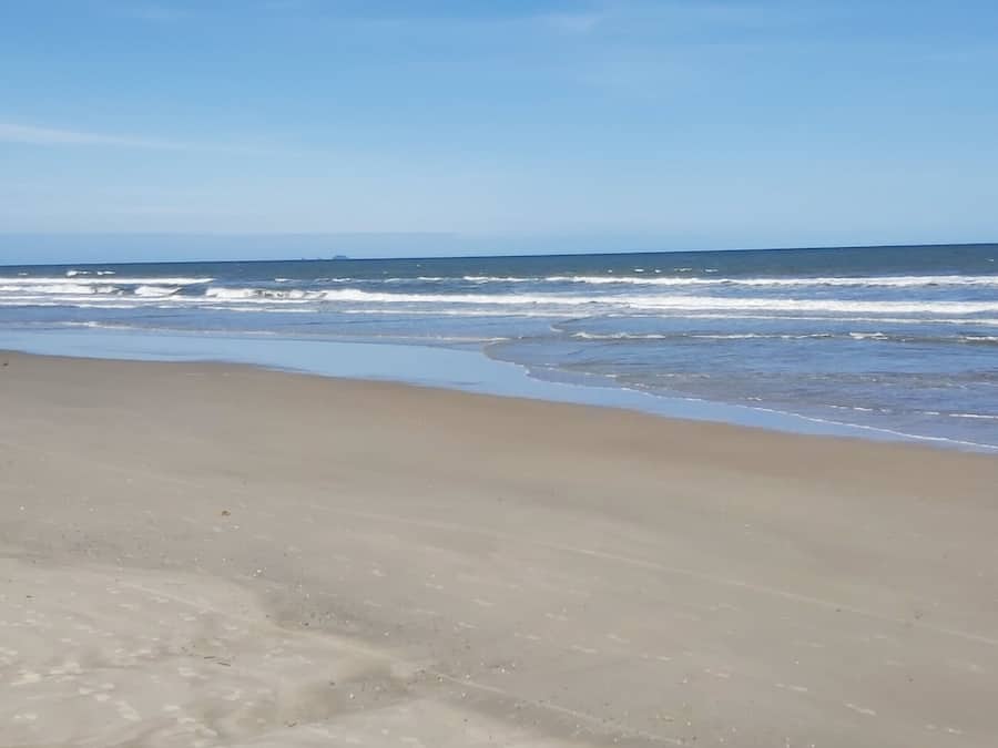 On the beach, sun-loungers, beach umbrellas, windsurfing