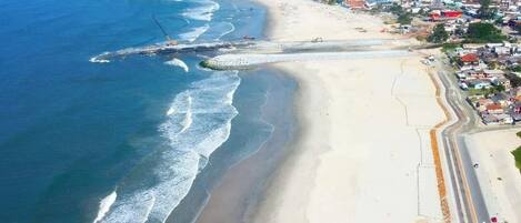 Rannalla, aurinkotuoleja, aurinkovarjoja, purjelautailumahdollisuus