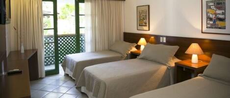 A hotel room with two beds, a ceiling fan, an air conditioner, a desk, and a view through a door to an outdoor area.