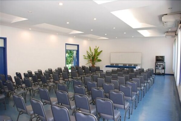 A conference room with rows of chairs, a whiteboard, and a plant. - Hotel 7 Colinas (Olinda)