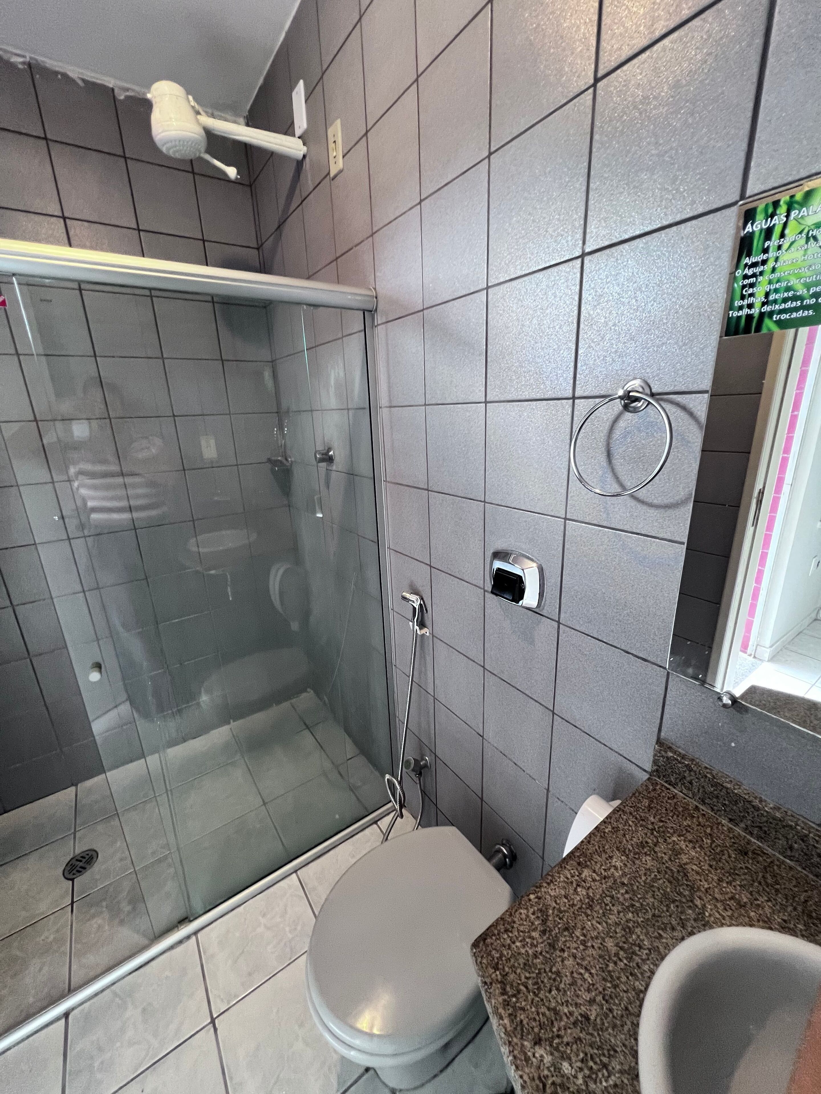 Un baño con ducha de vidrio, inodoro y lavamanos.