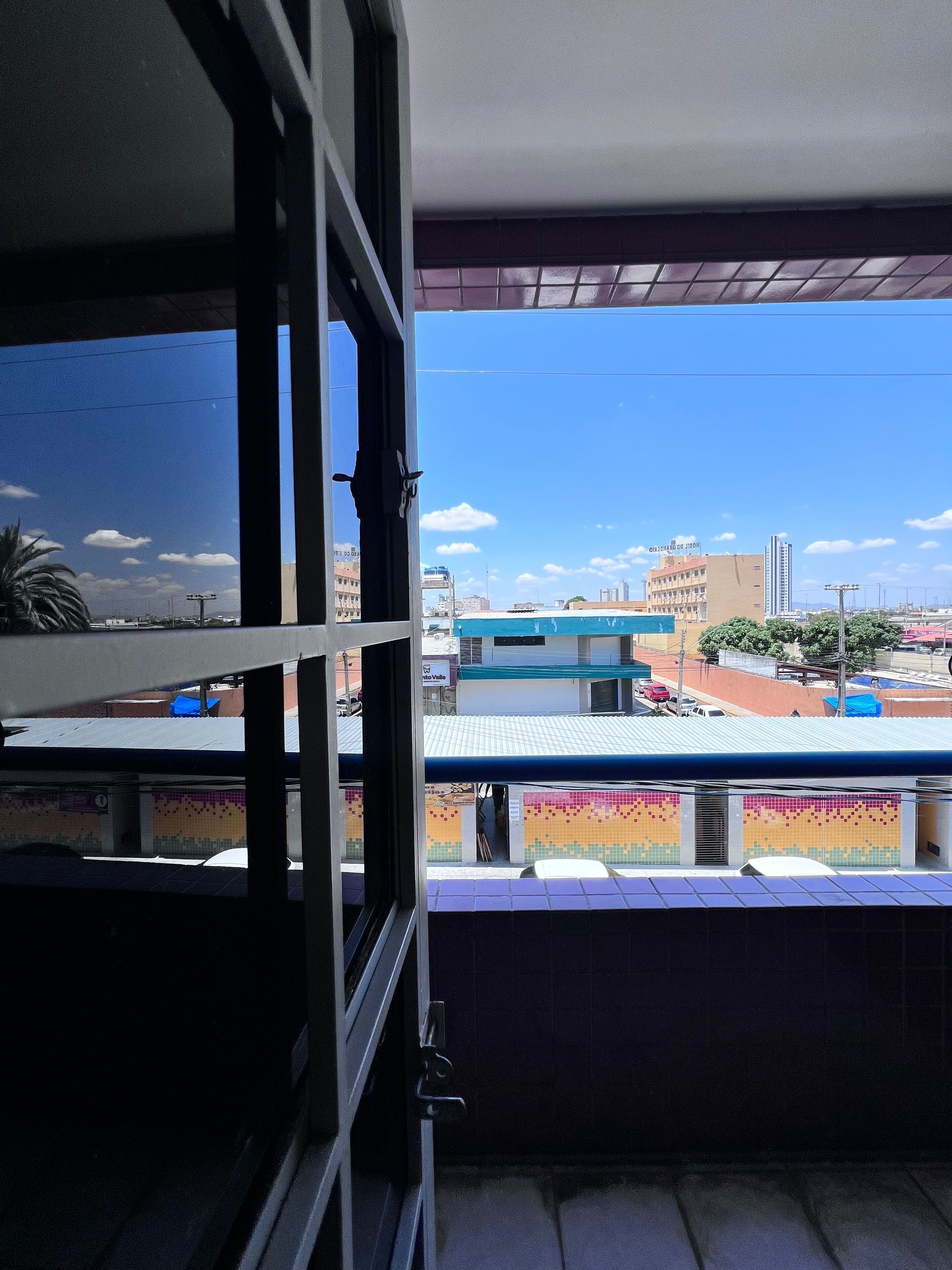 A balcony with a view of buildings and a clear sky.