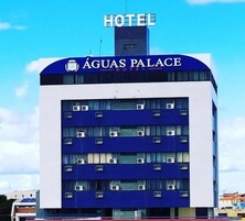 Un hotel llamado 'Águas Palace' con un diseño moderno, que cuenta con varios pisos y unidades de aire acondicionado visibles en el exterior.