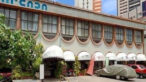 A building with a row of arched windows and a sign with blue letters. - Arcada Hotel E Bistrô (RECIFE)