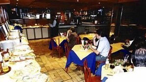 A restaurant with multiple tables and chairs, a bar area, and a buffet setup. - Arcada Hotel E Bistrô (RECIFE)