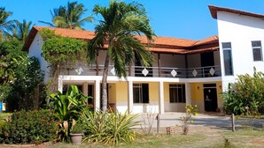 A two-story building with a red-tiled roof, white walls, and a balcony. - Delta Park (Parnaíba)