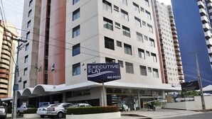 A multi-story building with a sign reading "EXECUTIVE FLAT RIO BODY". - Hotel Executive Flat Arrey (Teresina)