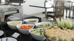 A buffet table with various food items including fruits, vegetables, and a salad. - Hotel Executive Flat Arrey (Teresina)