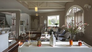 A spacious living room with a high ceiling, a dining area, and a view of the outdoors. - Pousada Doce Canela (Canela)