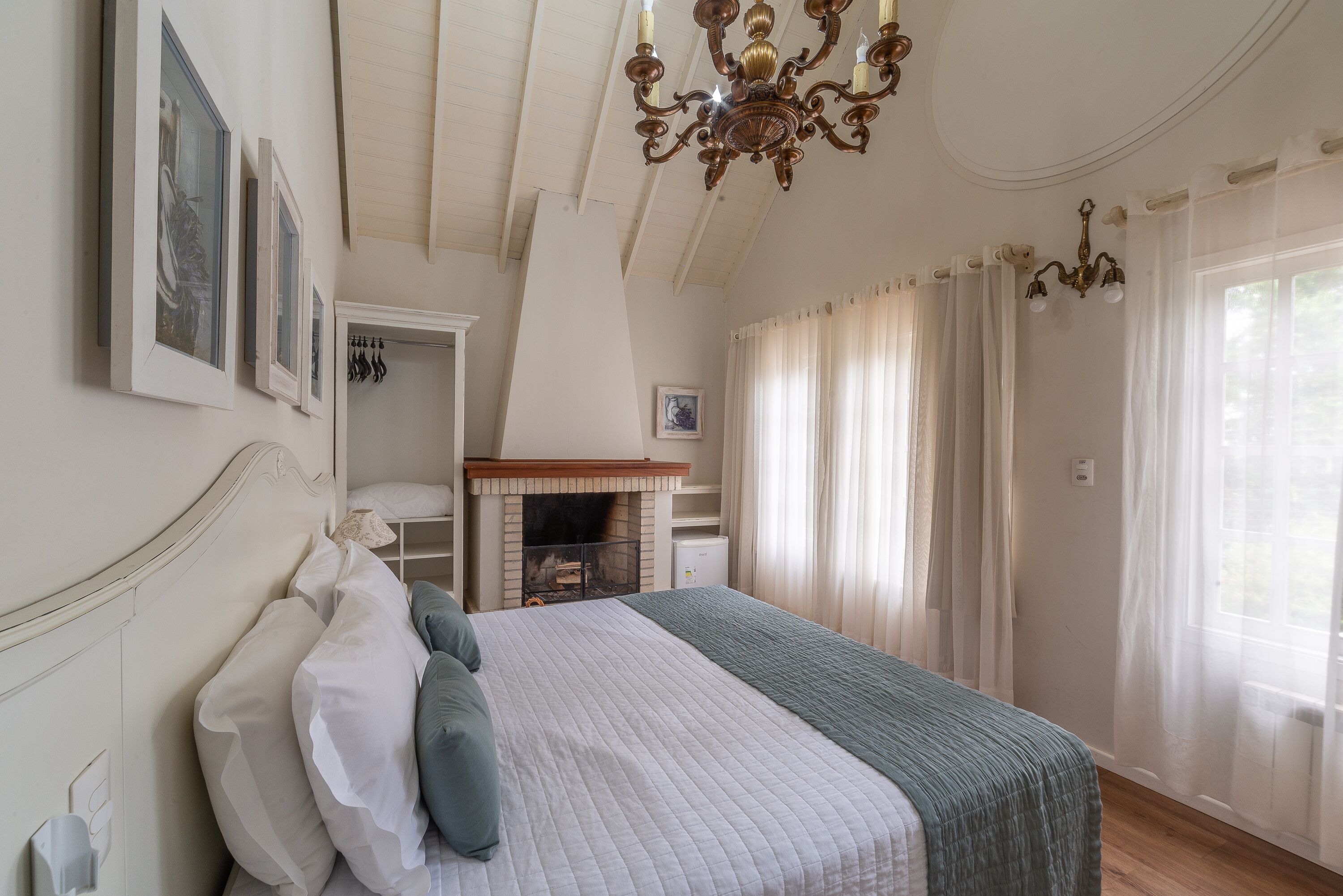 Un dormitorio con una cama grande, una chimenea y un candelabro.