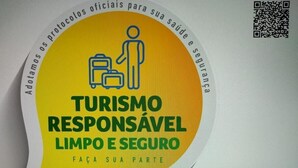 A circular sticker with a person and luggage, promoting responsible tourism. - Roma Hotel (Porto Alegre)