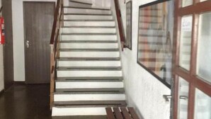 A staircase with wooden handrails, a bench, and a fire extinguisher on the wall. - Roma Hotel (Porto Alegre)