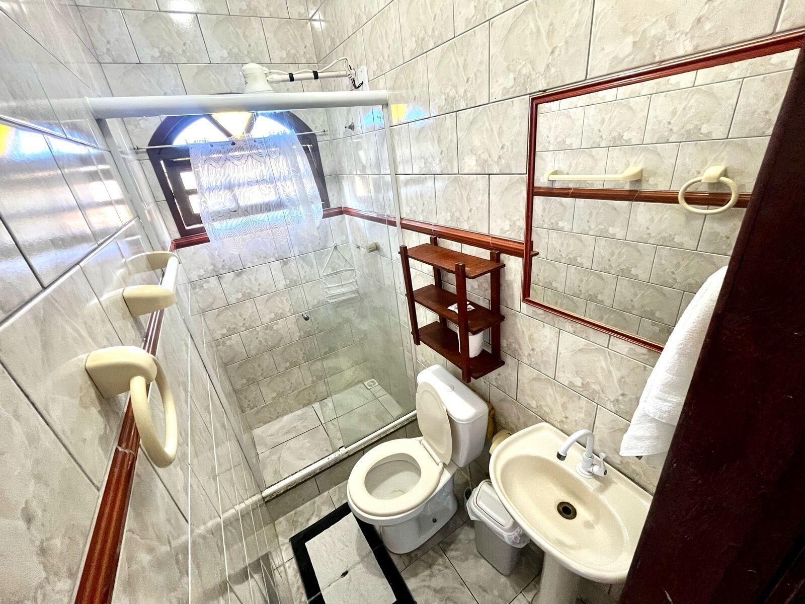 Une salle de bain avec des toilettes, un lavabo et une douche.