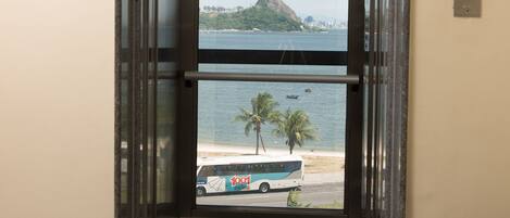 Un ascensor con vistas a una playa, palmeras y un autobús.