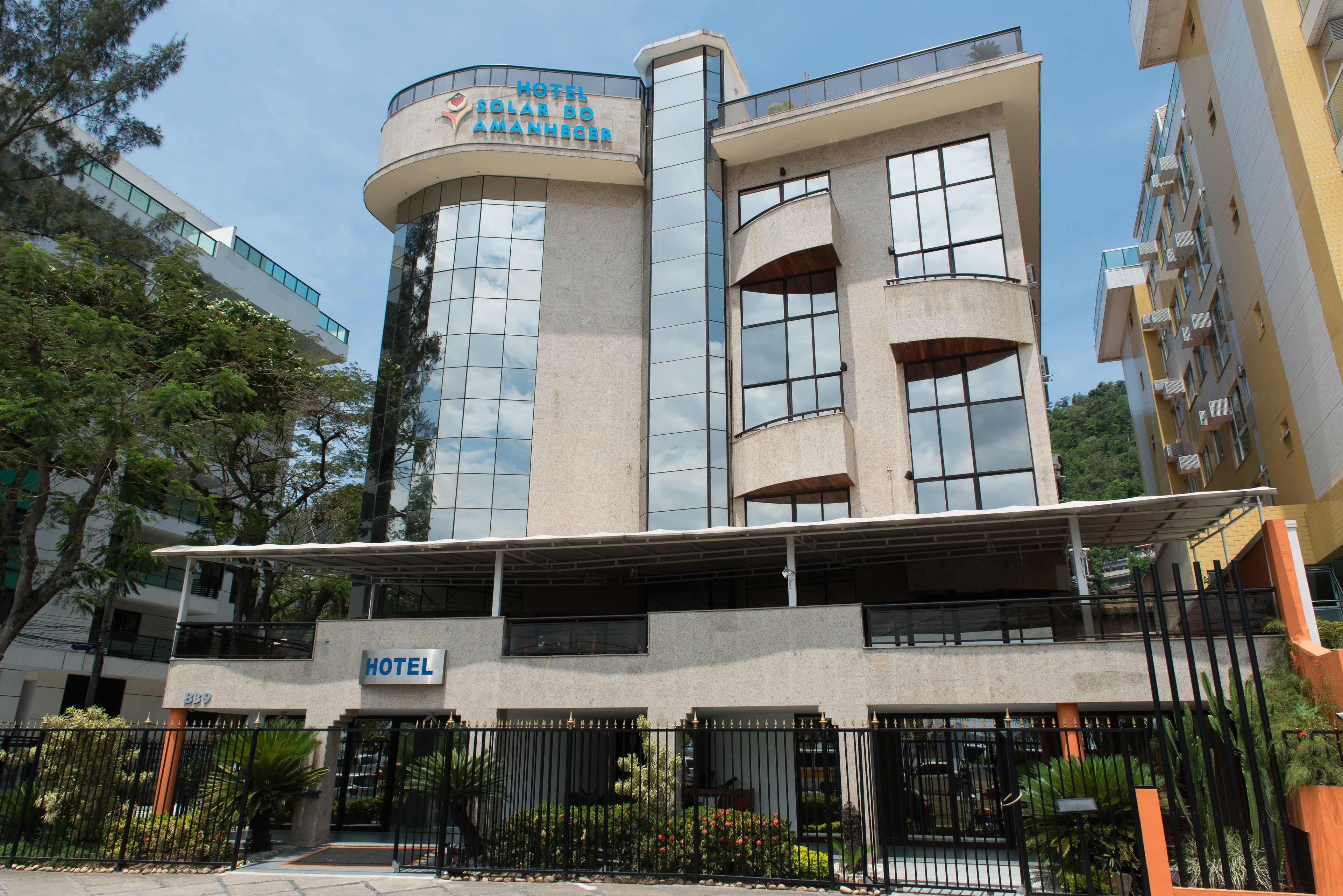 A modern hotel with a curved facade, large windows, and a sign indicating it is a hotel.