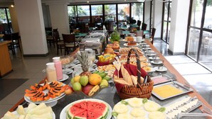 A buffet setup with various fruits, pastries, and beverages. - Solar do Amanhecer (Niteroi)