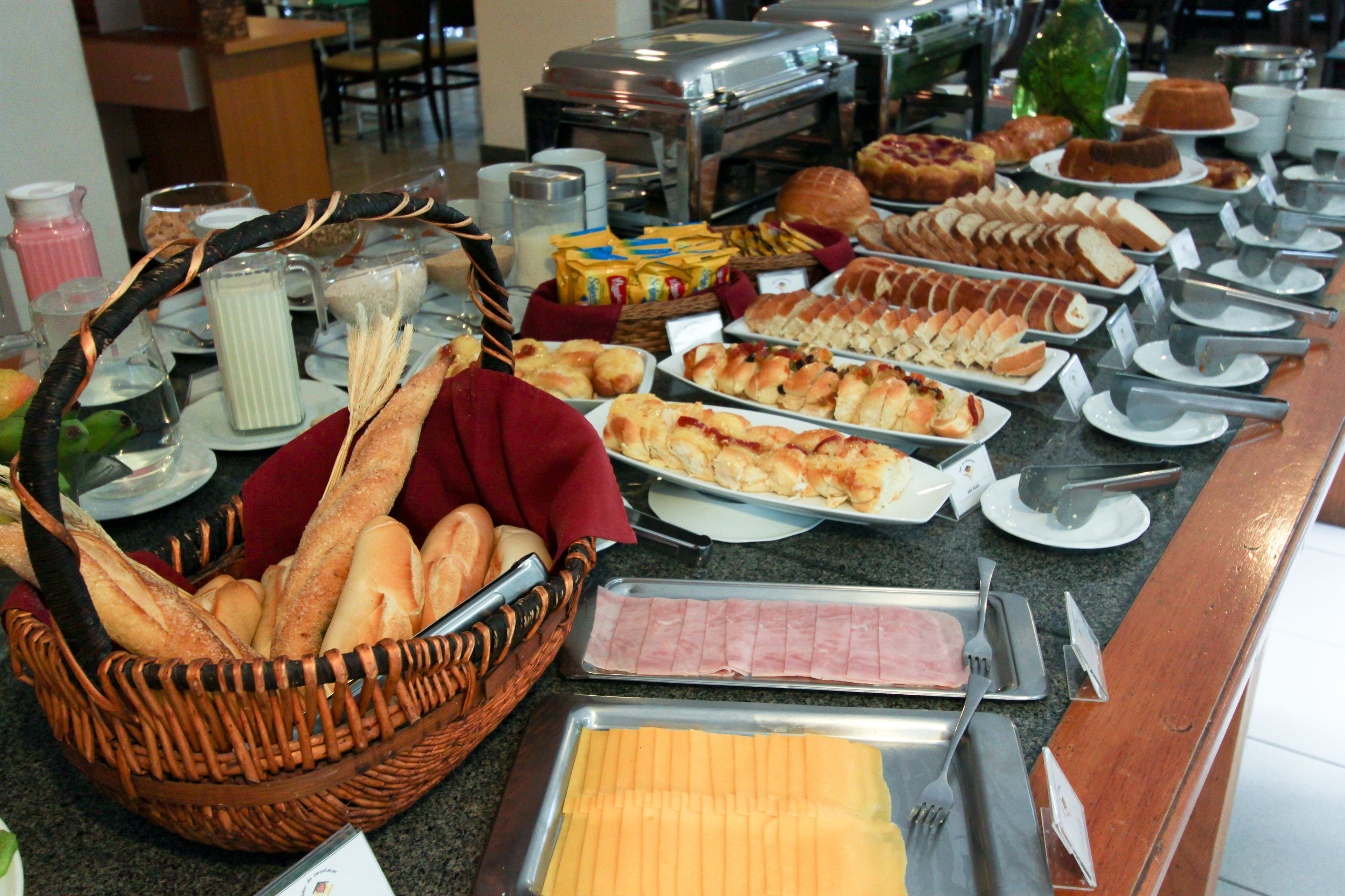 Un bufé con distintos alimentos, incluyendo pan, queso y carnes.