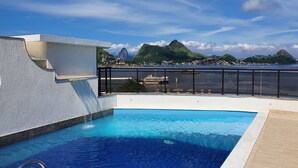 A rooftop swimming pool with a clear view of a cityscape and mountains in the background. - Solar do Amanhecer (Niteroi)