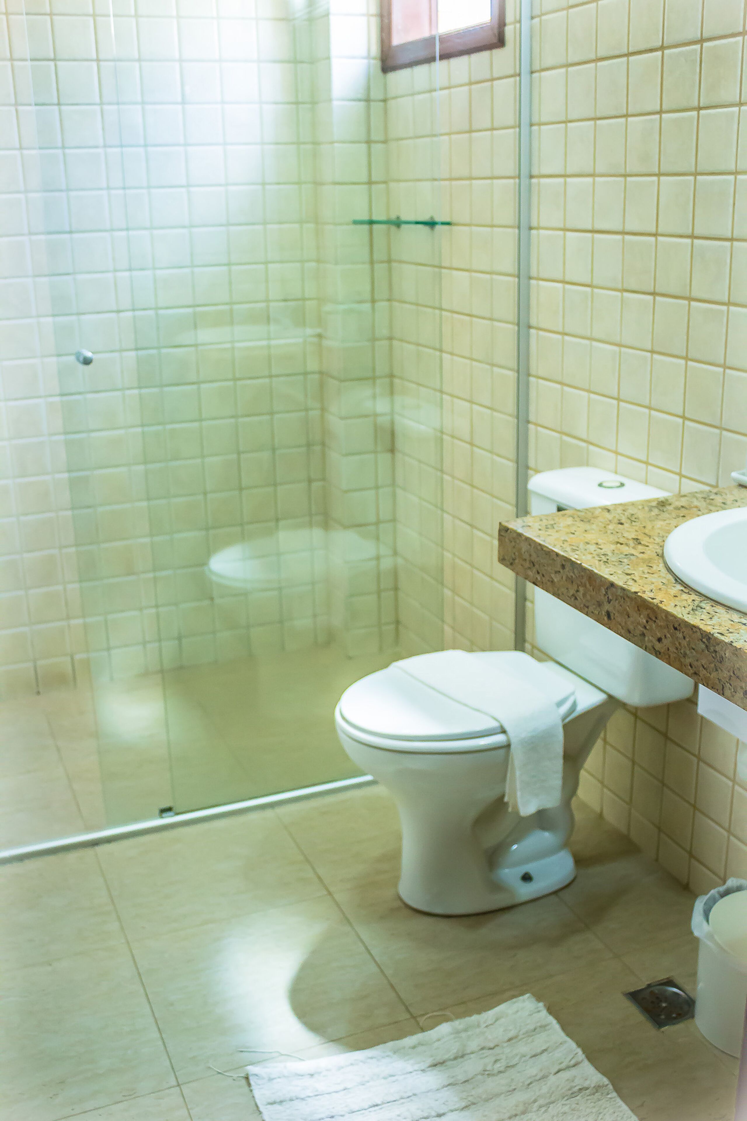 A bathroom with a toilet, a sink, and a shower area.