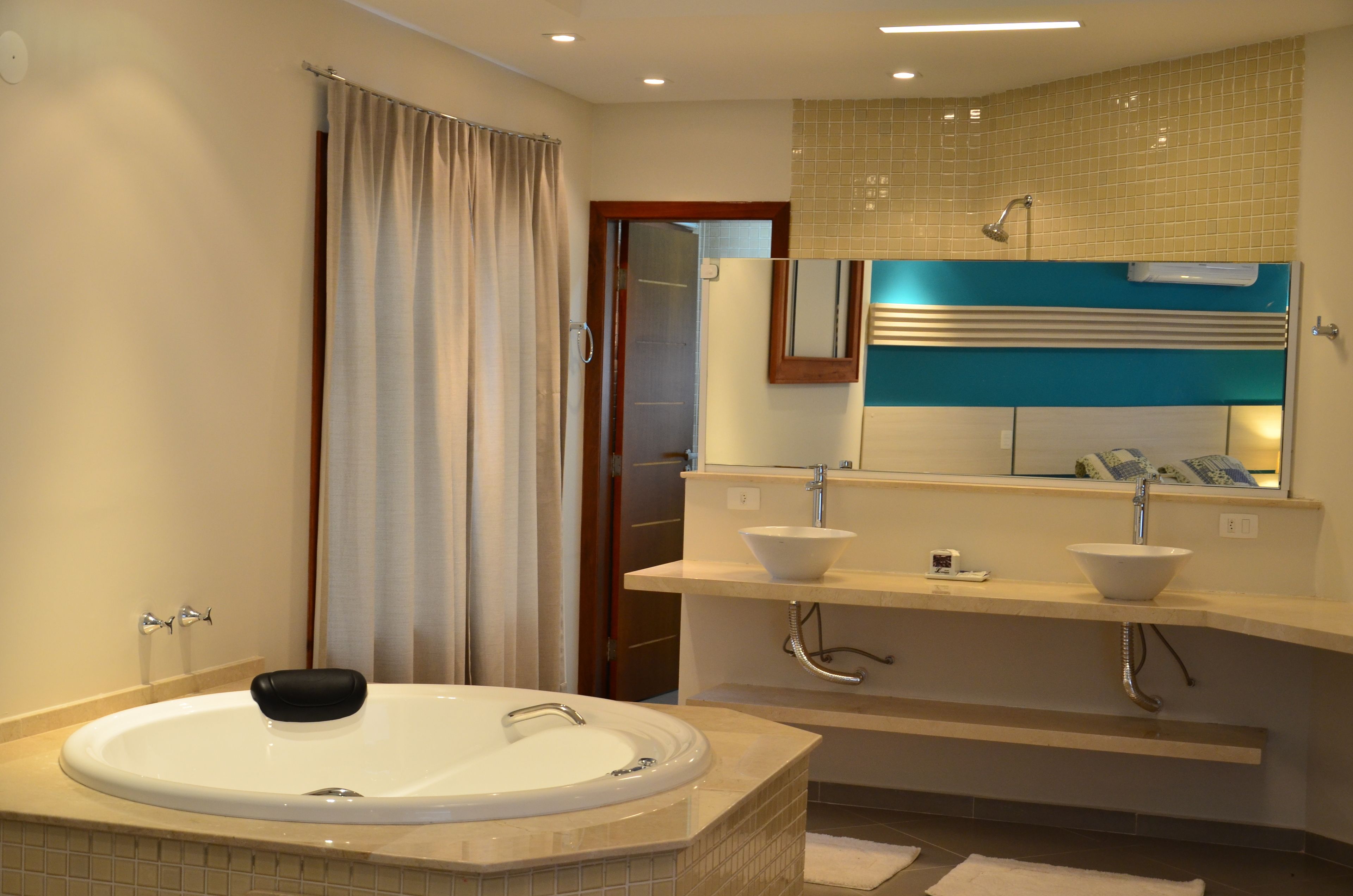 A modern bathroom with a freestanding bathtub, two sinks, a shower, and a mirror above the vanity.