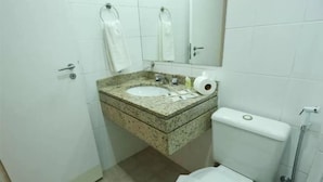 Ein Badezimmer mit Granitwaschtisch, Toilette und Dusche.