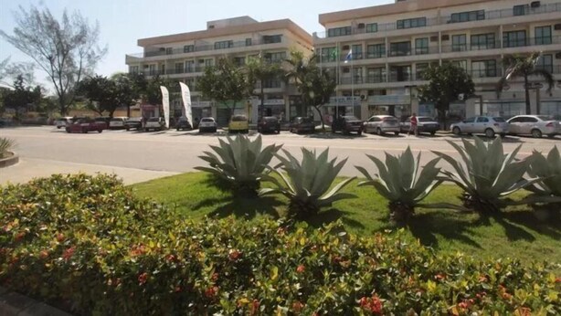 Ein mehrstöckiges Hotel mit Parkplatz davor.