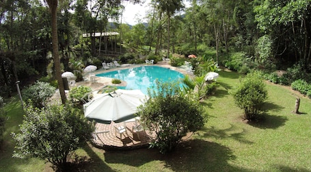 Una piscina al aire libre, sillones reclinables de piscina