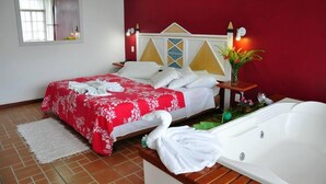 A hotel room with a bed, a bathtub, and a window. - Pousada & Spa Vrindavana (Teresópolis)