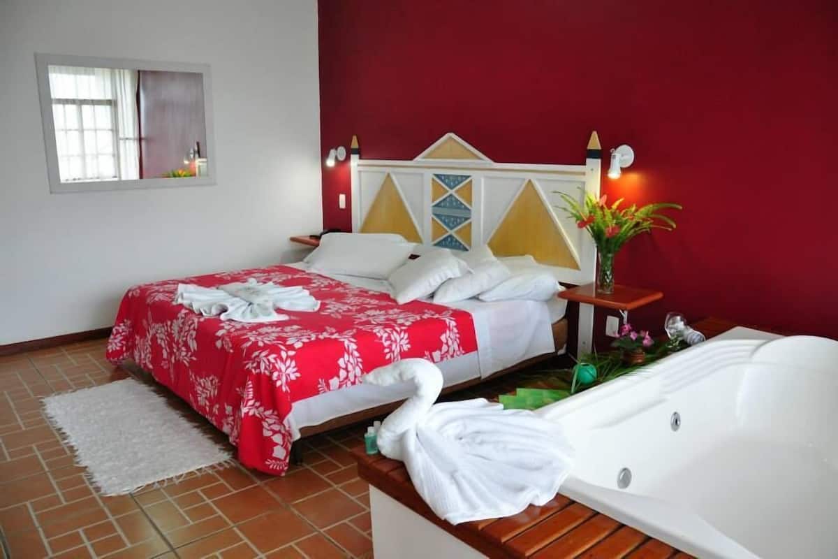 Ein Hotelzimmer mit Bett, Badewanne und Fenster.