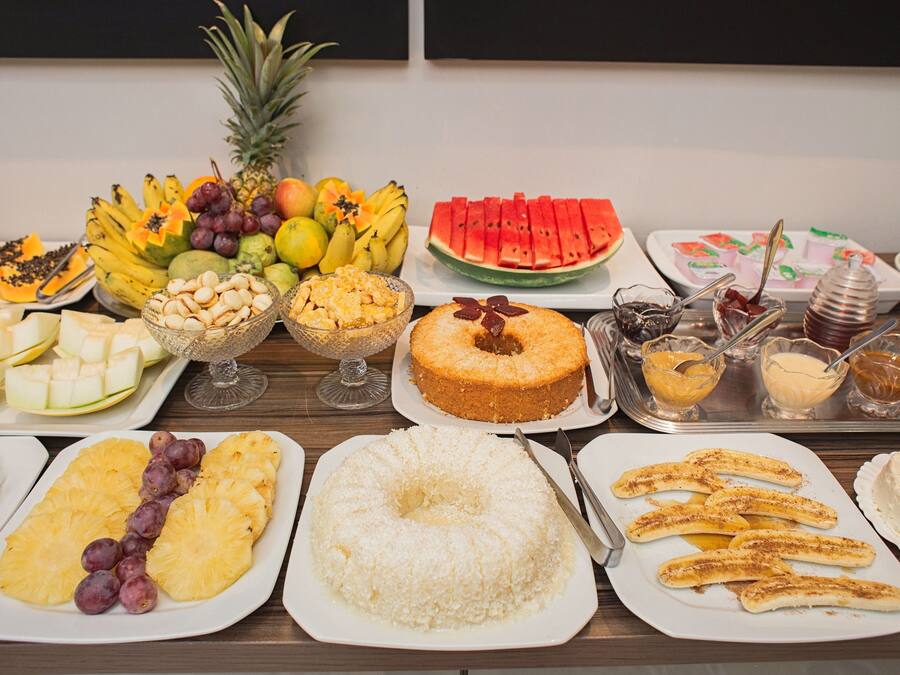 A buffet with various fruits, desserts, and beverages.