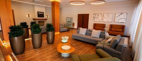 A modern living room with a sofa, coffee table, and potted plants.