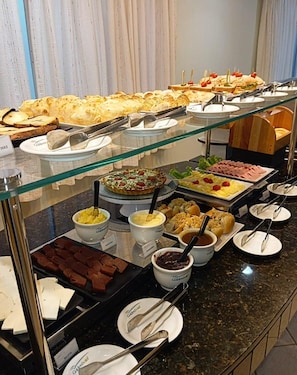 A buffet with various food items and utensils. - Golden Hotel (Chapecä)