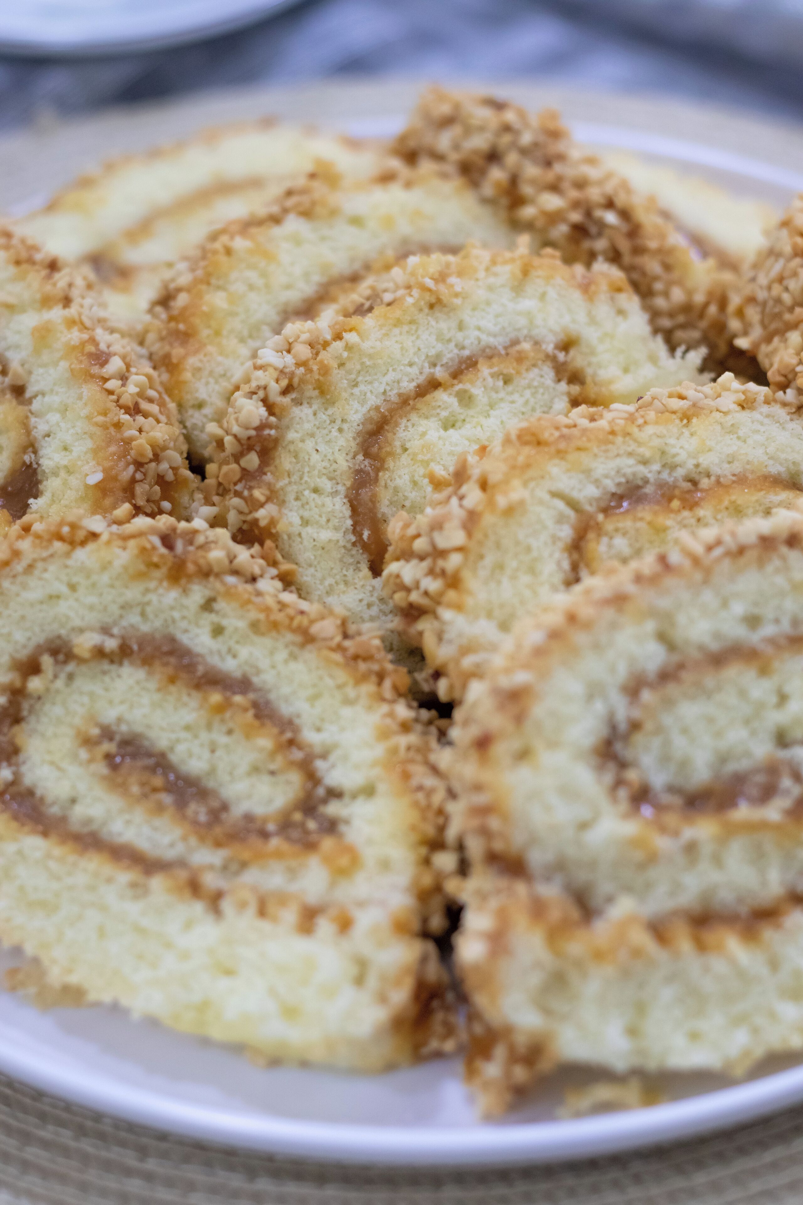Um prato de pastéis fatiados com recheio cremoso, possivelmente de canela ou nozes, e polvilhado com uma cobertura crocante.